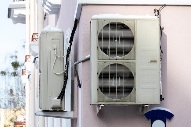 An outdoor air conditioner unit consisting of two fans A large industrial air conditioner on the wall of a store or enterprise Repair and maintenance of the air conditioning system