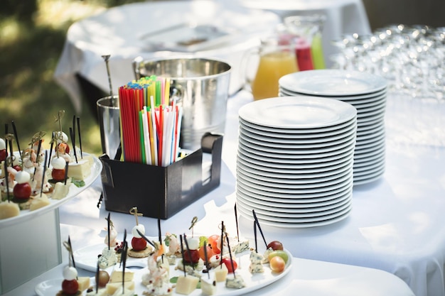 Photo outdoor catering banquet in summer table with snacks canapes and fruits at a summer banquet