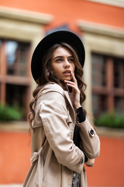 Outdoor fashion portrait of glamour sensual young stylish lady wearing trendy fall outfit and black hat on the street