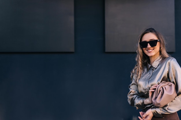 Outdoor fashion portrait of young elegant woman wearing beige bag