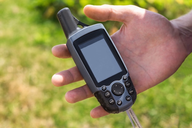 Outdoor GPS navigator tracker withblanc screen lying in man's hand