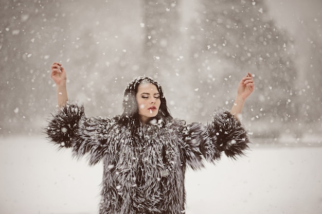 Outdoor lifestyle fashion photo of young natural beautiful lady in winter landscape