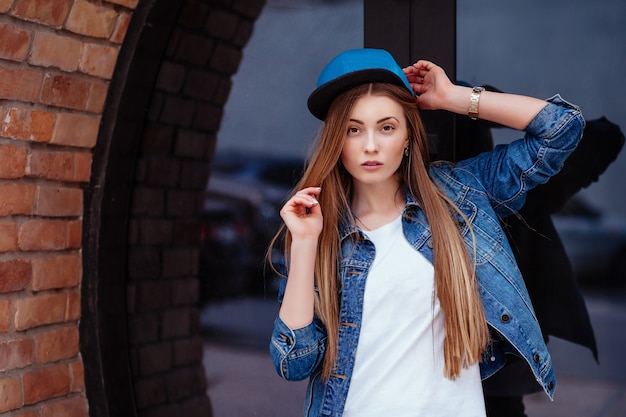 Outdoor lifestyle portrait of pretty young girl, wearing in hipster swag grunge style on urban background