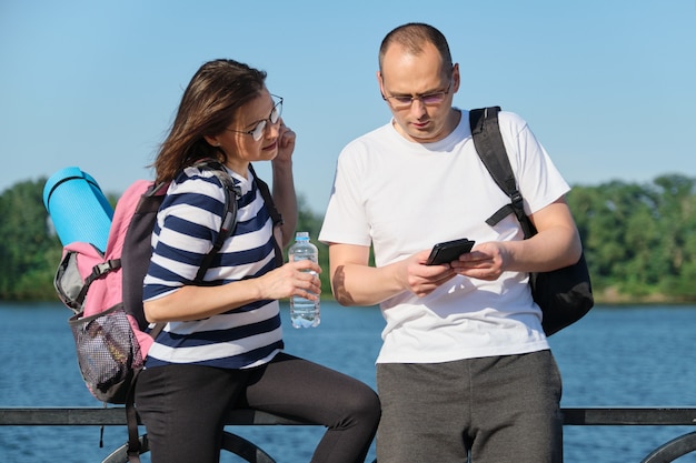 Outdoor mature couple using smartphone