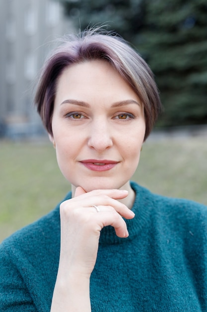 Outdoor portrait of an attractive stylish short cut woman