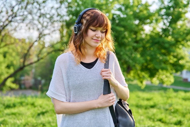 Outdoor portrait of beautiful smiling teen female student with backpack