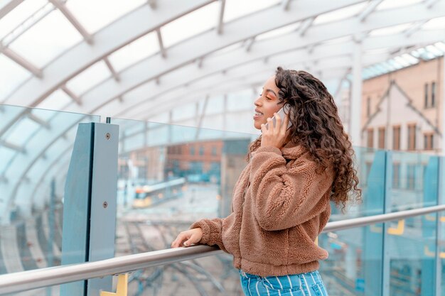 Outdoor portrait of a happy woman talking on the phone in urban city in England