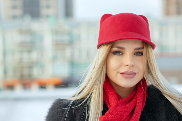 Photo outdoor portrait of lovely girl wearing stylish red cap and knitted scarf