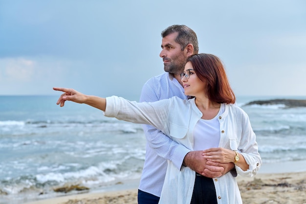 Outdoor portrait of mature couple hugging on the seashore