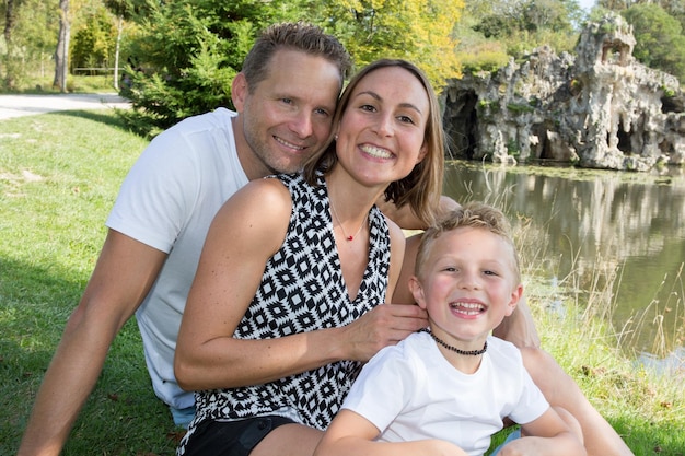 Outdoor portrait pond park happy family Mother father and child son