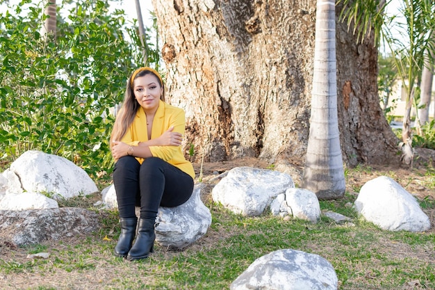 Outdoor portrait of woman in yellow jacket Portrait of young Mexican woman in a garden at sunset