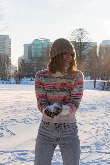 Outdoor portrait of young beautiful fashionable happy smiling woman winter portrait, woman in winter hat, snow. enjoying winter moments