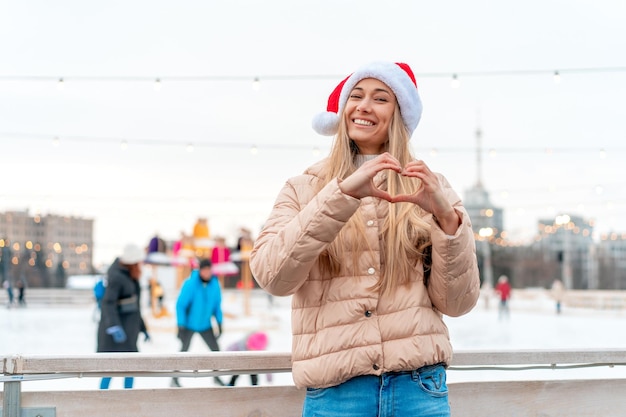 Outdoor portrait young beautiful fashionable woman wearing Santa hat