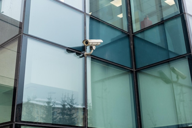 Outdoor security camera on green glass wall