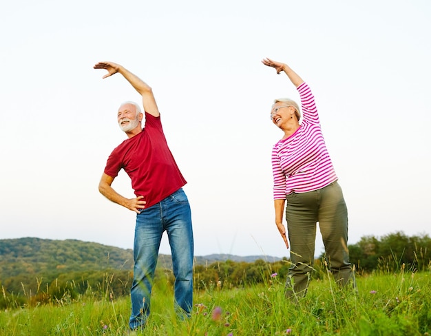 Photo outdoor senior fitness woman man lifestyle active sport exercise healthy fit retirement stretching elderly couple