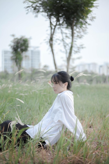 Outdoor shot of attractive dark haired female wearing white t shirt and short looking away raising