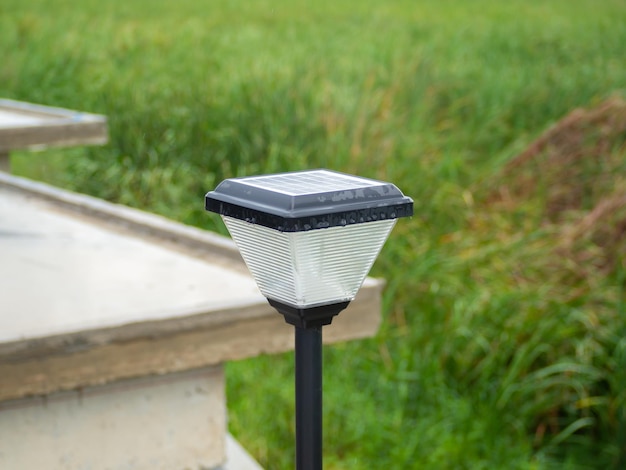 Outdoor solar light for houses, buildings. Green grass background and house roof.