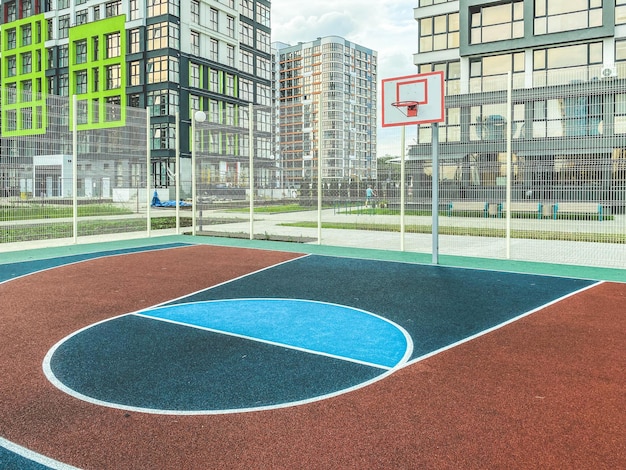 Outdoor sports basketball court in a residential area ball game next to tall glass houses