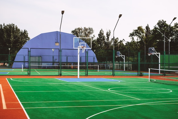 Outdoor sports field with artificial turf for playing tennis and basketball.