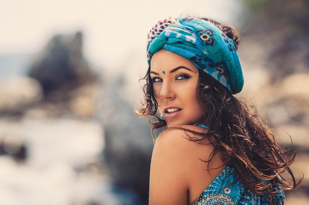  Outdoor summer portrait of young pretty woman in oriental style clothes and accessories on the beach 