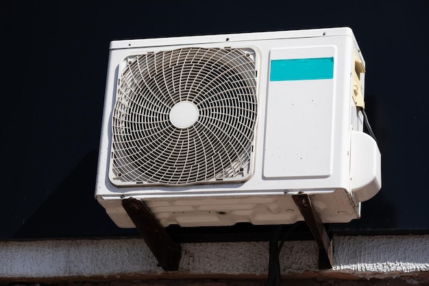 Outdoor unit of a domestic air conditioner with a fan outside the building