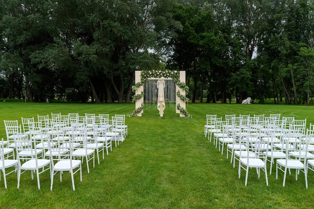 Outdoor wedding of a park A beautiful dress is hanging on the wedding arch Front view