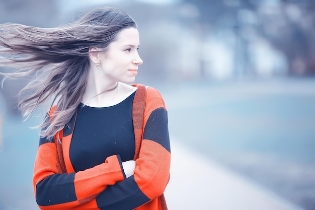 Outdoor wind hair fall / autumn portrait adult girl model woman with long hair in a windy day in the park