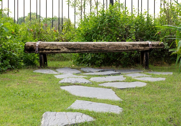 Outdoor wooden chair in garden with stone pattern walk way