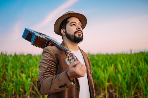 Outdoor of a young Latin American man and guitar. Brazilian musician.