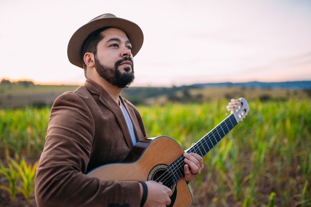 Outdoor of a young Latin American man playing guitar. Brazilian musician.