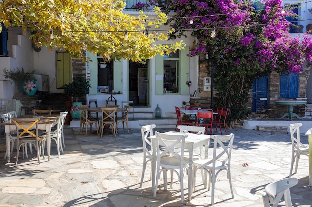 Outdoors cafe at Tinos island Dio Horia village Cyclades Greece Wooden table chair on paved yard