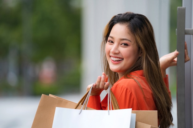 Outdoors portrait of Happy woman holding shopping bags