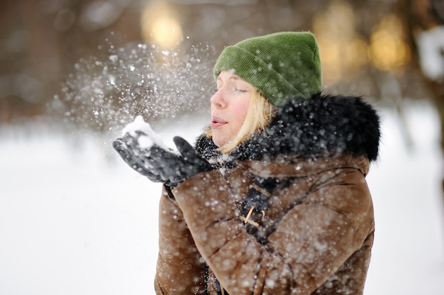 Outdoors portrait of young beautiful woman having fun in winter.