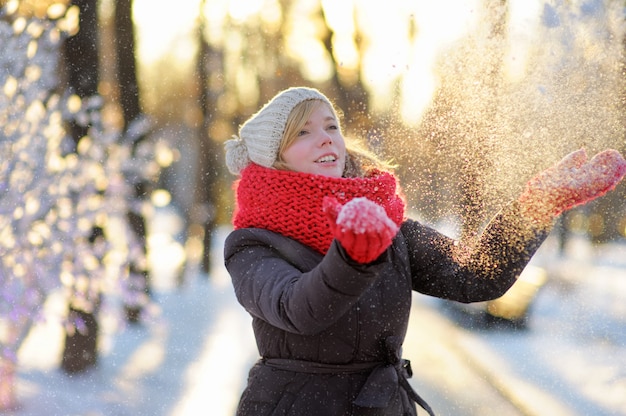 Outdoors portrait of young beautiful woman having fun in winter 