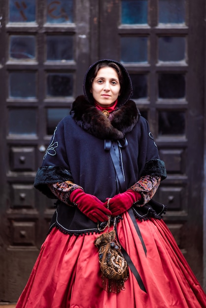 Outdoors portrait of a young victorian woman walking old city