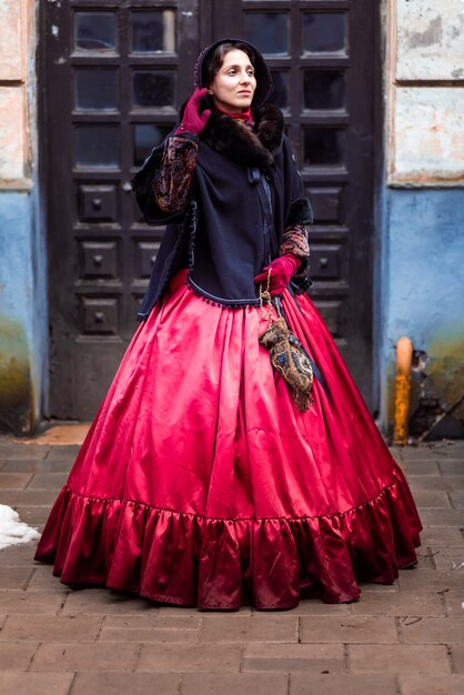 Outdoors portrait of a young victorian woman walking old city