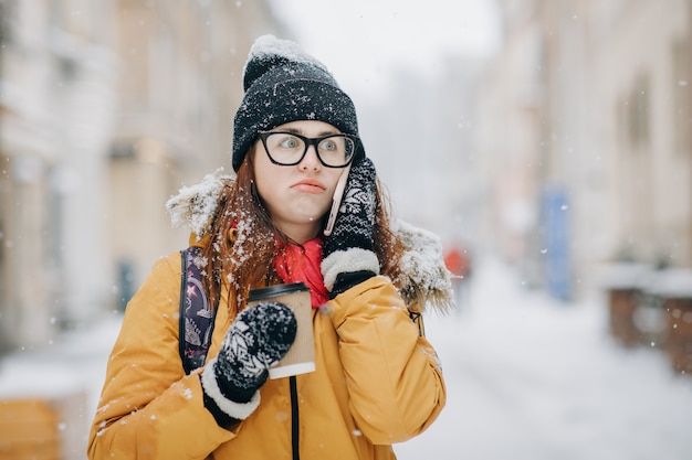 Outdoors winter portrait of beautiful teenage girl speaking on the phone