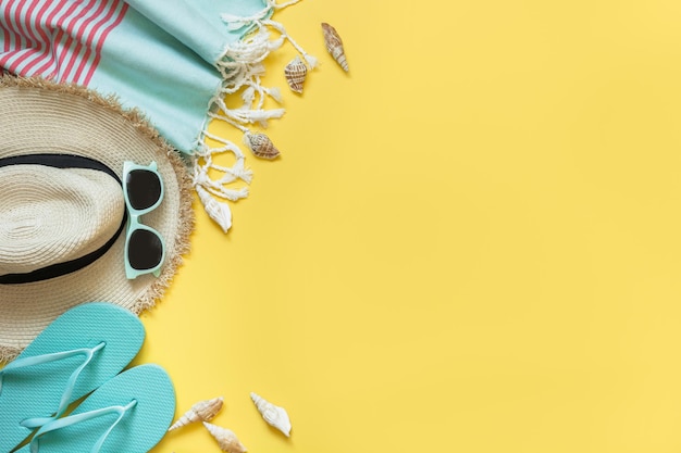 Outfit for beach and tropical vacations straw sunhat sun glasses on yellow Summer