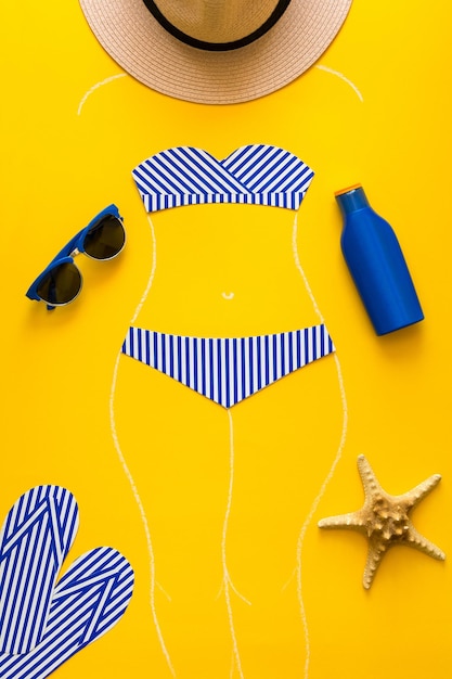 Outlines of girl in paper swimsuit drawing by chalk Beach accessories