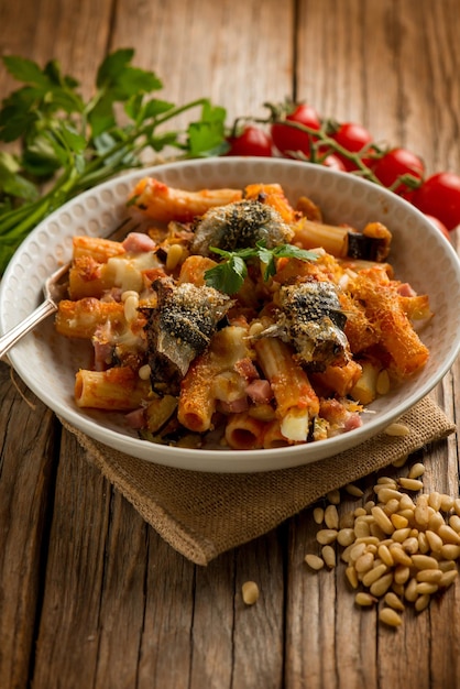 Oven pasta with sardines eggplants pine nuts tomato and parsley