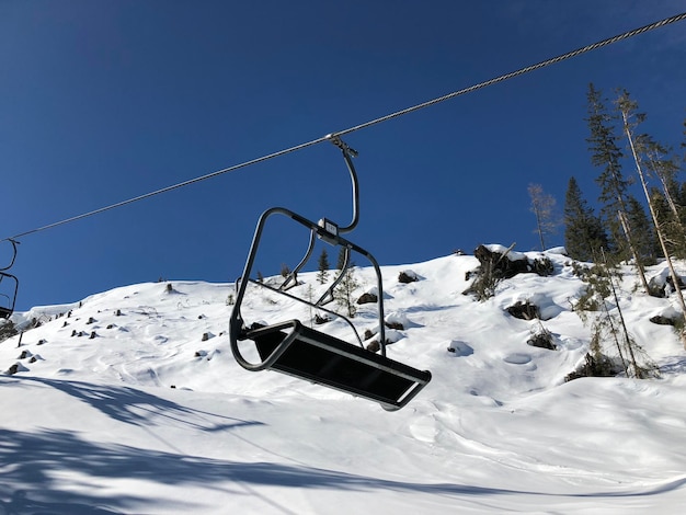 Overhead cable car on snow covered mountain against sky