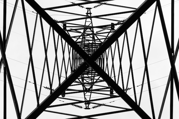 Under overhead high-voltage power line tower. View from bottom of construction