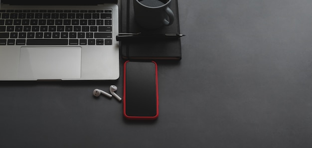 Overhead shot of laptop computer and smartphone with copy space on black table