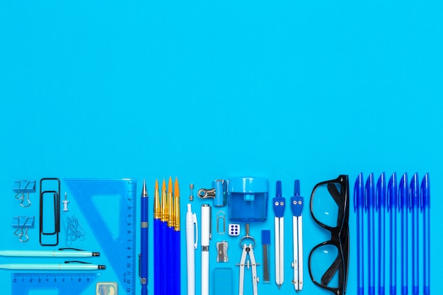 Photo overhead shot of school supplies on blue background