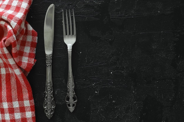 Overhead shot of silverware on black table with copy space