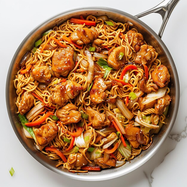 overhead shot stainless steal pan filled with yakisoba chicken with cabbage and carrots white