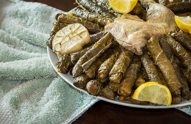 Overhead shot of a traditional Arabian meal of grape leaves with chicken meat served with lemons