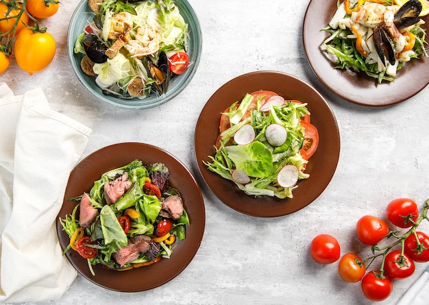 Overhead view of assortment of salads on wooden table