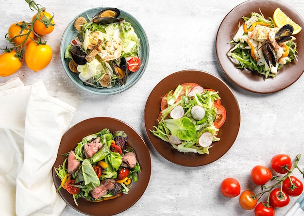 Overhead view of assortment of salads on wooden table