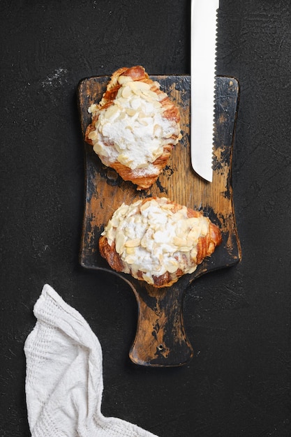 Overhead view of crispy croissant with caramel on wooden serving board